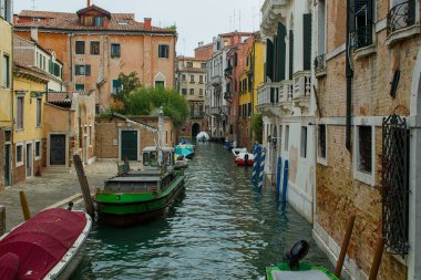 Venedik, İtalya - 15 Ekim 2024: Venedik, İtalya Palazzo Sereno 'nun yanındaki yumuşak kanalı çevreledi. Dar su yolları eski cepheleri yansıtıyor. Eski duvarlar arasında küçük tekneler sessizce sürüklenir..