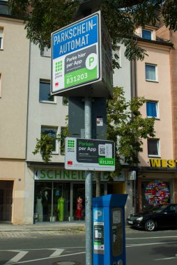 Nuremberg, Almanya - 24 Ağustos 2025: Bu mavi park makinesi Almanya 'nın Nuremberg şehrinde bir sokakta duruyor. Parkschein-Automat tabelası PayByPhone üzerinden uygulama parkını destekliyor. Şehir ayrıntıları.