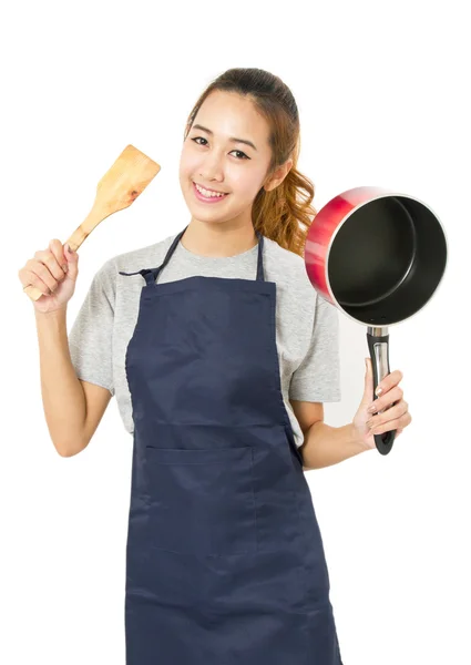Ásia mulher vestindo avental e mostrando pan com utensil — Fotografia de Stock