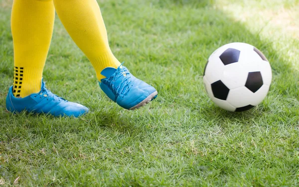 Atleta pateando una pelota de fútbol en el campo . —  Fotos de Stock