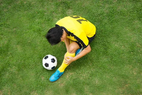 Jugador de fútbol en Amarillo acostado herido en el campo . —  Fotos de Stock