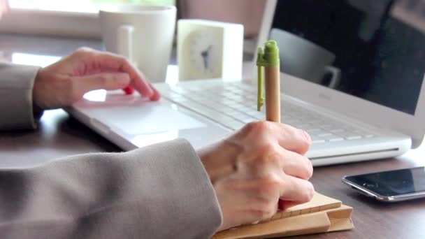 Рука закрыть бизнес-женщина запись на ноутбуке и работа с ноутбуком в офисе . — стоковое видео