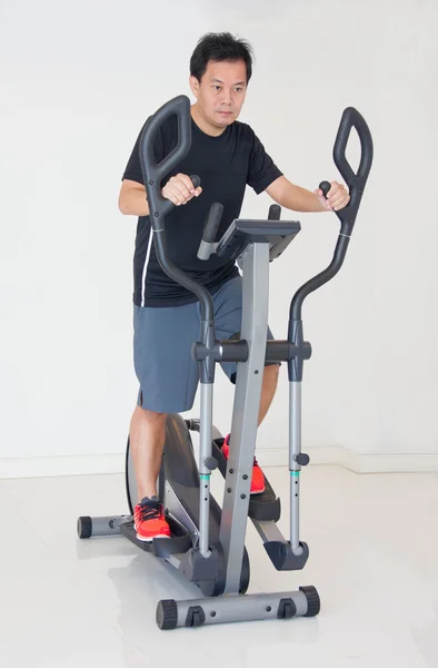 Asain Man Doing Exercises On Elliptical Cross Trainer At Fitness Center. — Stock Photo, Image