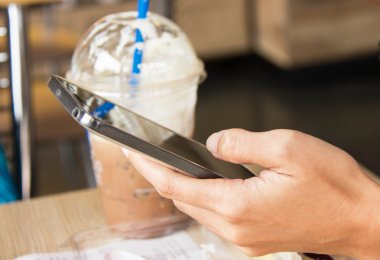 Kahve dükkanında akıllı telefon kullanarak kadın ele