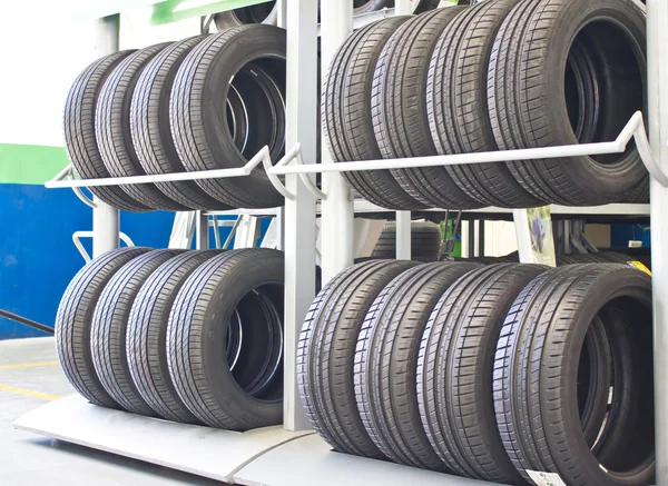 Filas de neumáticos nuevos en rack —  Fotos de Stock