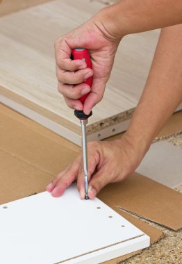 Ahşap mobilya montaj tornavida kullanarak Asya elini.