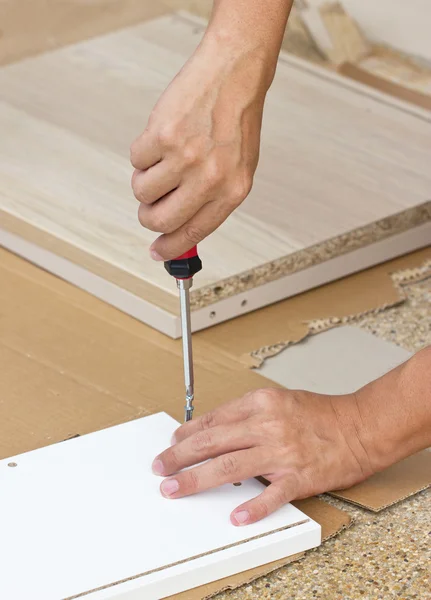 Mano dell'uomo asiatico facendo uso del driver a vite che monta mobilia di legno . — Foto Stock