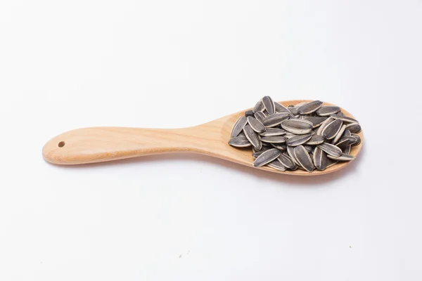 Semillas de girasol con cuchara de madera aislada sobre fondo blanco . — Foto de Stock