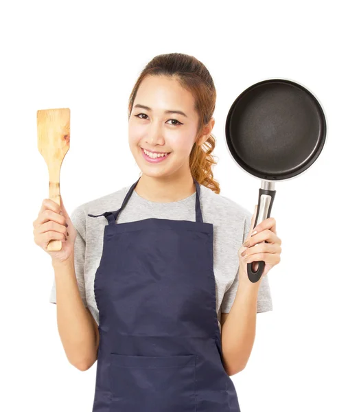 Ásia mulher vestindo avental e mostrando pan com utensil . — Fotografia de Stock