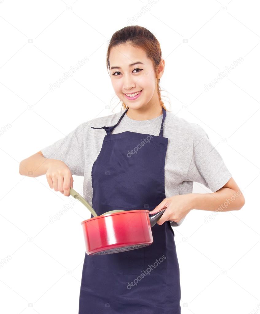 Asian Woman Wearing Apron And Showing Pot With Utensil