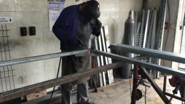 Adam bir çit garaja çerçevesinde kaynak. Sparks Kaynak Makinası