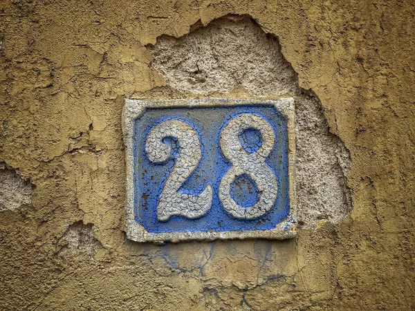 28番 アパート 通りの数 青金属板上の白地番 荒壁上の28番 28番 — ストック写真