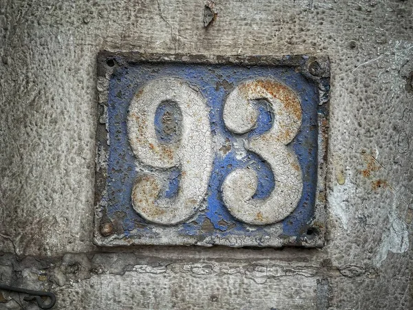 93番 アパート 通りの数 青金属板上の白色の番号 荒壁の家番号93 — ストック写真