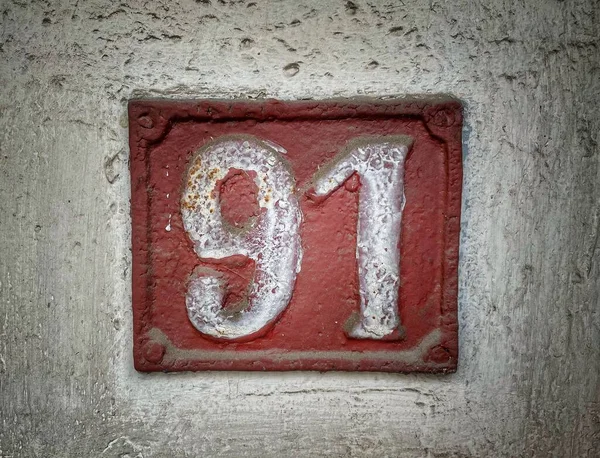 91号 街道的数量 褐色金属板上的白色号码 粗糙墙上的91号房子 — 图库照片