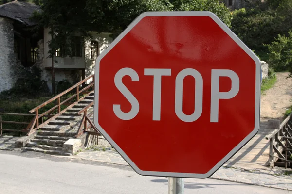 Panneau rouge sur une route en pierre — Photo