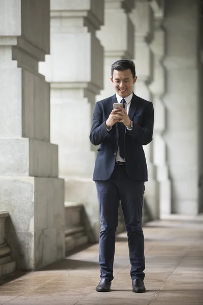 Chinese businessman using his Smartphone