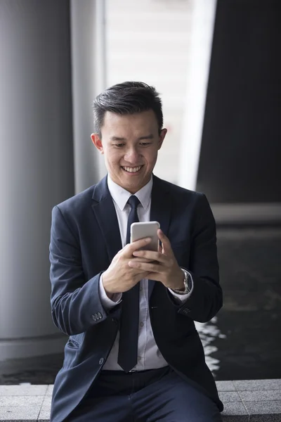 Chinese businessman using his Smartphone