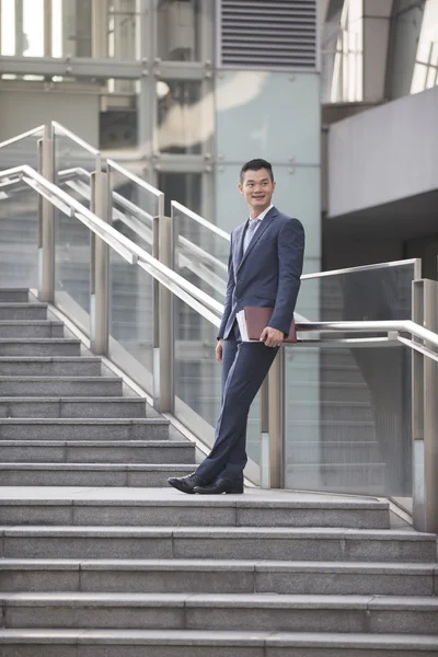 Asian businessman standing outdoors.