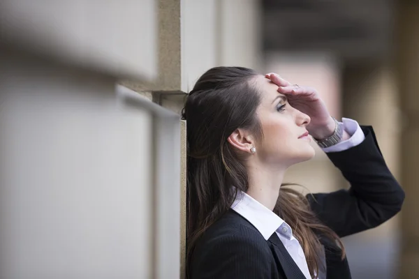 Angry businesswoman banging head against wall