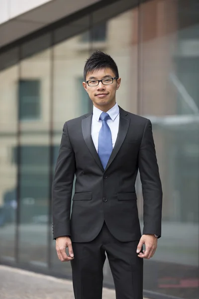 Asian businessman outside office building.