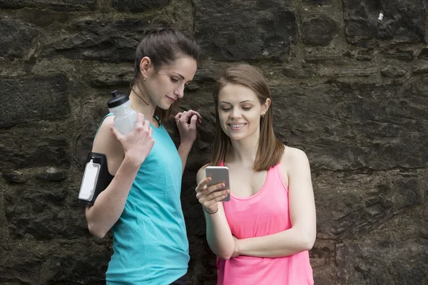 female runners sharing information on smartphone