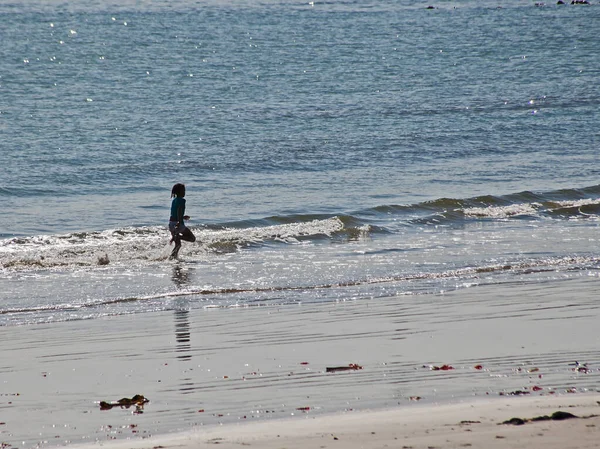 stock image A candid shot of a little girl running in the surf at Hondeklip Bay. South Africa