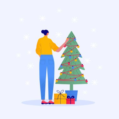 Noel karakteri dekorasyonu. Genç ve güzel bir kadın Noel ağacını süslüyor. Noel ağacının altında hediyeler