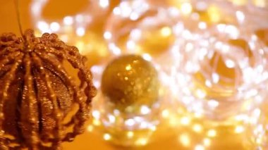 Altın noel çelenkleri, parıldayan çelenkler, dönen Noel balosu, bulanık odak. Kış tatilinin arka plan videosu