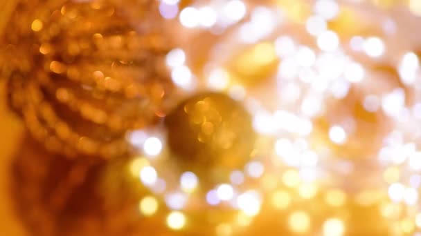 Arany karácsonyi bokeh fény és csillogó koszorúk elmosódott fókusz. háttér videó a téli nyaralás — Stock videók