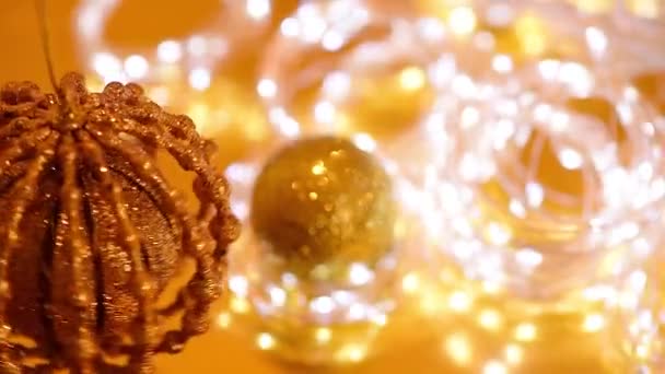 Золотий різдвяний боке легких і мерехтливих гірлянд, різдвяний м'яч прядіння, розмитий фокус. фон відео зимових канікул — стокове відео