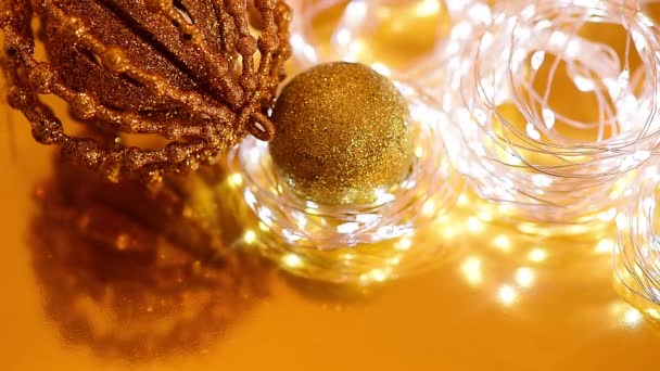 Bokeh de Navidad de oro de guirnaldas ligeras y centelleantes, bola de Navidad, enfoque borroso. video de fondo de las vacaciones de invierno — Vídeo de stock