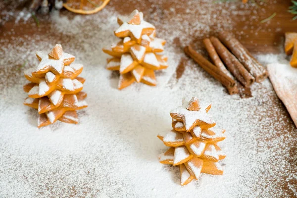 Biscoitos de gengibre caseiros Árvores de Natal decoradas com açúcar em pó em um fundo de guirlandas bokeh leves. composição de anos novos 2021 — Fotografia de Stock