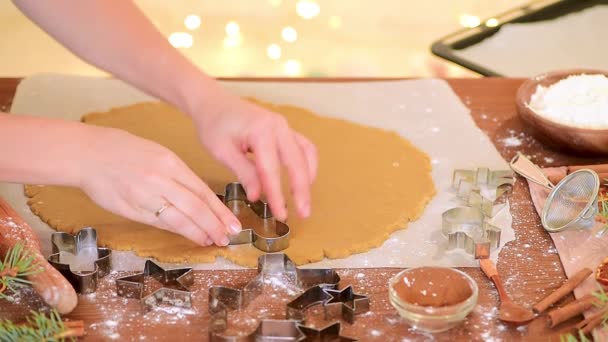 Damskie ręce wyciąć domowej roboty piernik świąteczny z ciasta, przygotowując się do pieczenia. bokeh od światła girlandy na tle — Wideo stockowe