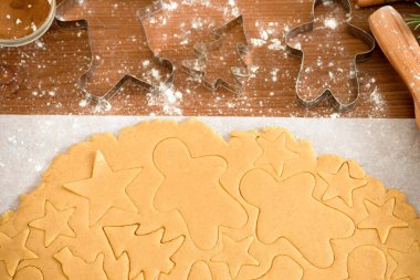 Zencefilli ekmek kalıbını kullanarak hamurdan zencefilli ekmek kes, üst manzara, tarçınlı çiğ hamuru pişirmek için hazırla. figürlerin hamurundaki desen.