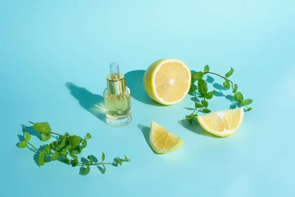 face serum with citrus fruit lemon and vitamin C in a glass bottle with a pipette on a blue background, the concept of self-care skin care at home.