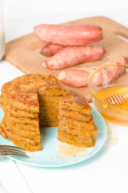 Ev yapımı sonbahar krepleri, üzerinde tatlı patates ve Chia tohumları olan vejetaryen krepler, düşük kalorili kahvaltı, cesetle ilgilenmek. Hafif bir arka planda bal ile sulanır. Dilimlenmiş krep..