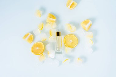 limonlu yüz serumu, limonlu kozmetik dondurma ve mavi ışık arka planında cilt bakımı için C vitamini, evde bakım için doğal organik malzemeler, detoks. metin için yer.