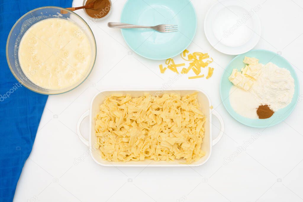 step-by-step recipe for the holiday of Hanukkah, a traditional Kugel pie with noodles and custard, sand crumbs on top. the ingredients in the dishes on a light background. mixing food in a baking dish.