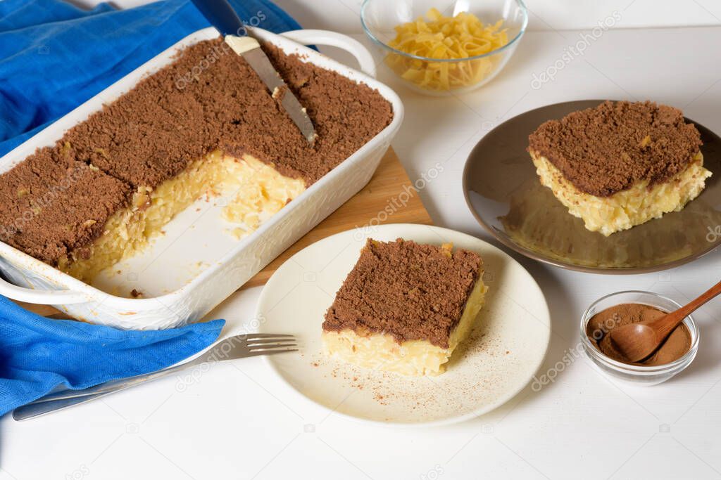 Hanukkah holiday, traditional sweet Kugel pie with noodles and custard, shortbread cocoa crumbs on top. on a light background in a baking dish. pie slices on a plate.