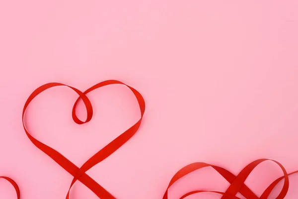 Walentynki Krzywe Czerwonej Wstążki Kształcie Serca Różowym Tle Świąteczne Tło — Zdjęcie stockowe