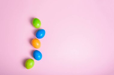 Paskalya bayramı rengarenk yumurta renginde pastel pembe arka planda. kompozisyon Paskalyası.