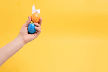 Paskalya bayramı sarısı arka planı için tavşan kulaklı renkli yumurtalar. Poster için arkaplan, metin için yer.