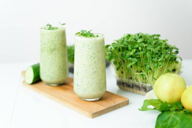 Hafif arkaplanda mikro-yeşil elma salatalığı ve ıspanak. Eko organik taze gıda detoksu. İçindekiler taze mikro-yeşiller. yakın çekim seçici odak.