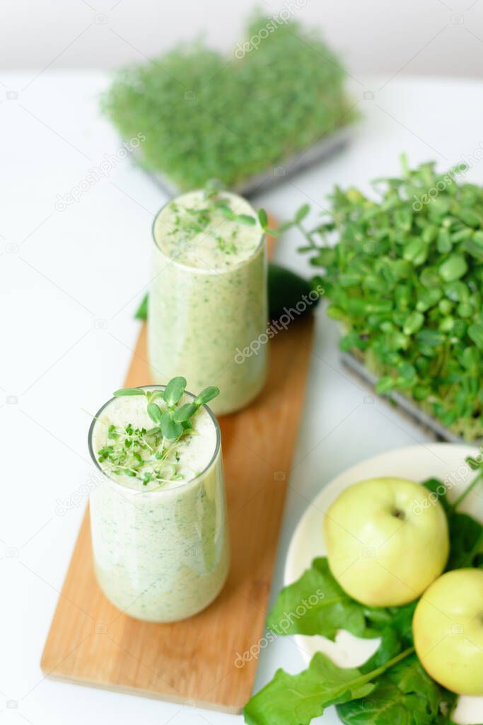 smoothie of micro-green apples cucumber and spinach on a light background. eco organic fresh food detox . ingredients fresh micro-greens . close-up selective focus.