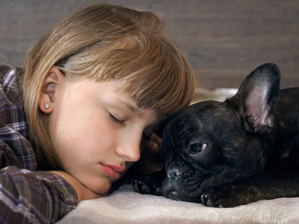 Girl and dog face to face. She sleeps.