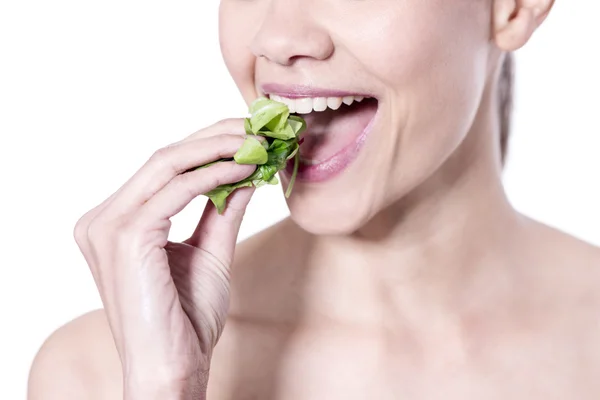 Vrouwelijke eten groene blad — Stockfoto