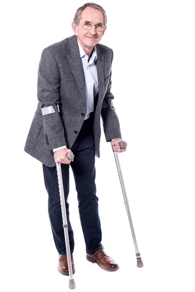 Hombre caminando con dos muletas — Foto de Stock