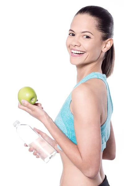 Atleta femenina con botella de agua y manzana — Foto de Stock