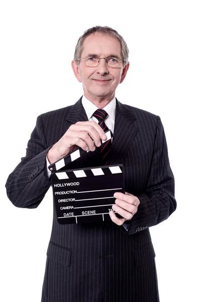 Aged businessman holding clapperboard — Stock Photo, Image