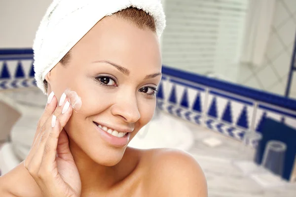 Mujer aplicando crema para el cuidado de la piel —  Fotos de Stock